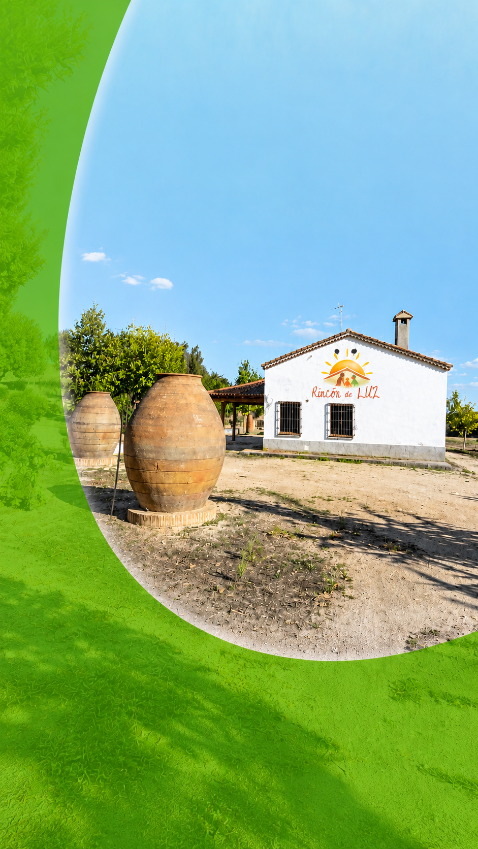 Entrada de la finca de Rincón de LUZ, con dos grandes tinajas de barro junto a la casa rodeada de arbolado